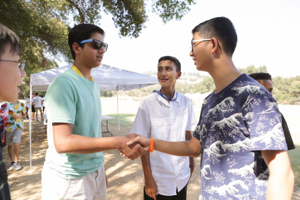 Students shaking hands at orientation and becoming friends
